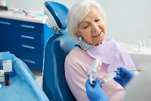 Patient listens to dentist explain how to prepare for upcoming dental implant surgery