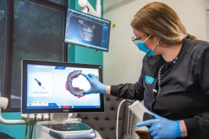 Lewis Dentistry Dentist gesturing towards the Dentspy Sinora dental equipment.