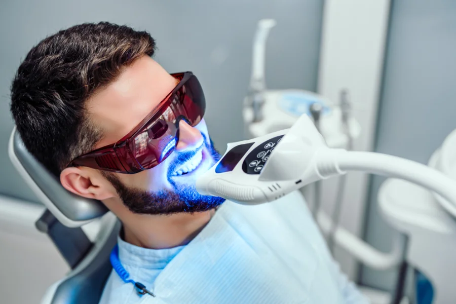 A man in a dental chair getting his teeth whitened